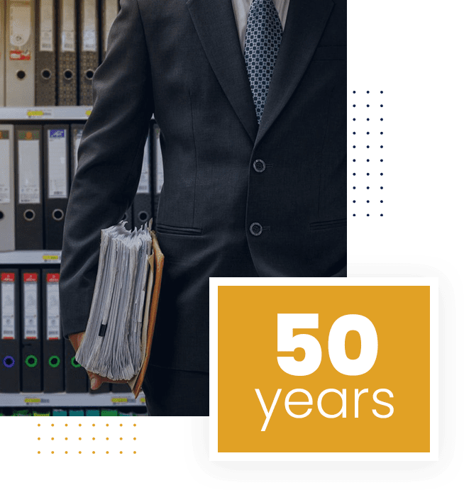 A professional holding a briefcase in an office with files.