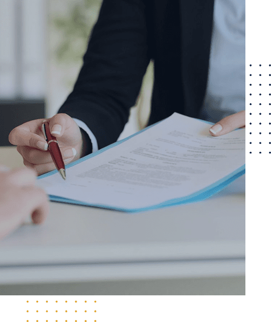 Person reviewing and signing a document at a desk.